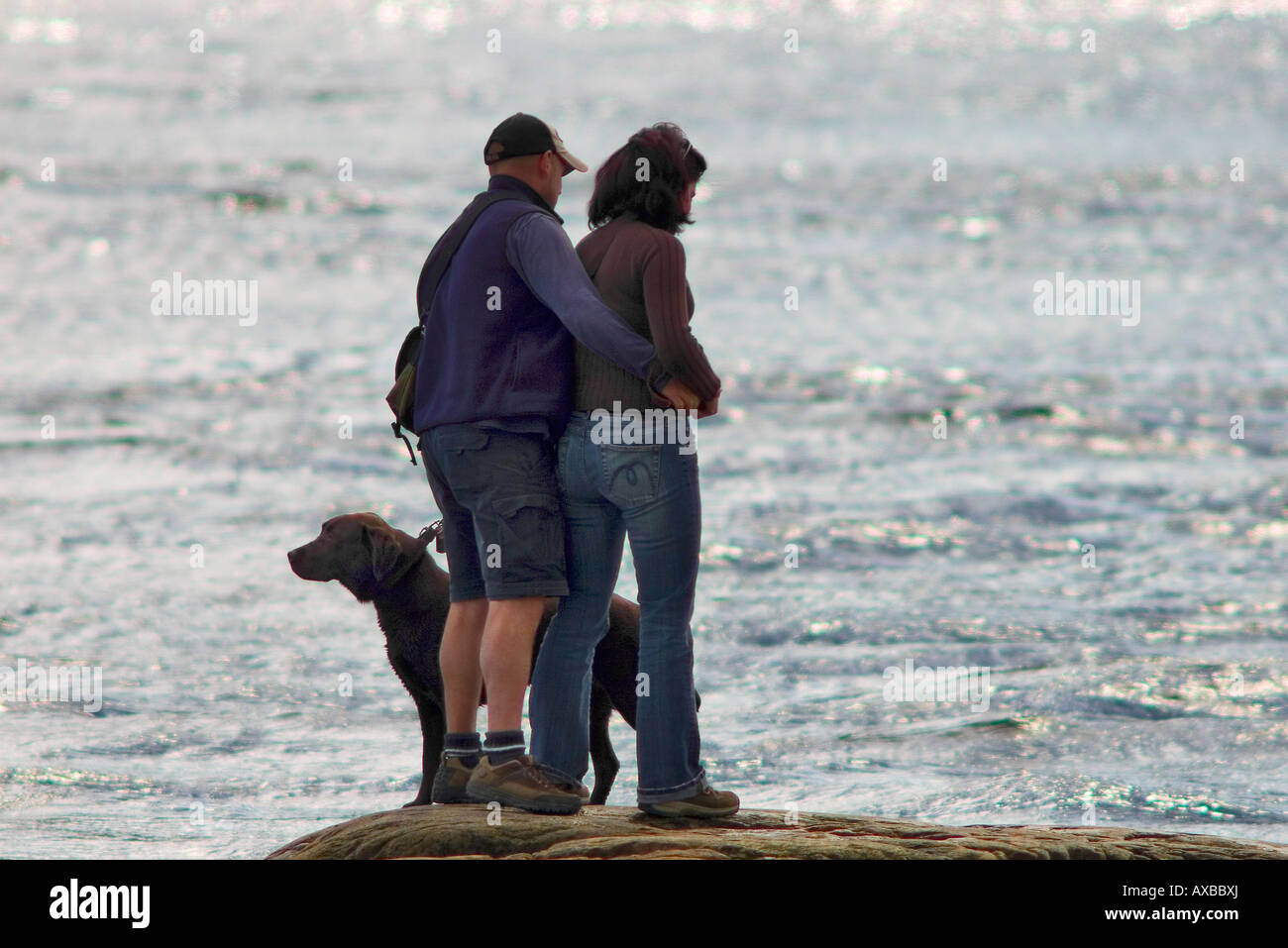 Ein Tourist paar stehen auf Felsen mit ihrem Hund Naturbeobachtung von Saguenay-Fluss-Ufer in Tadoussac Stockfoto