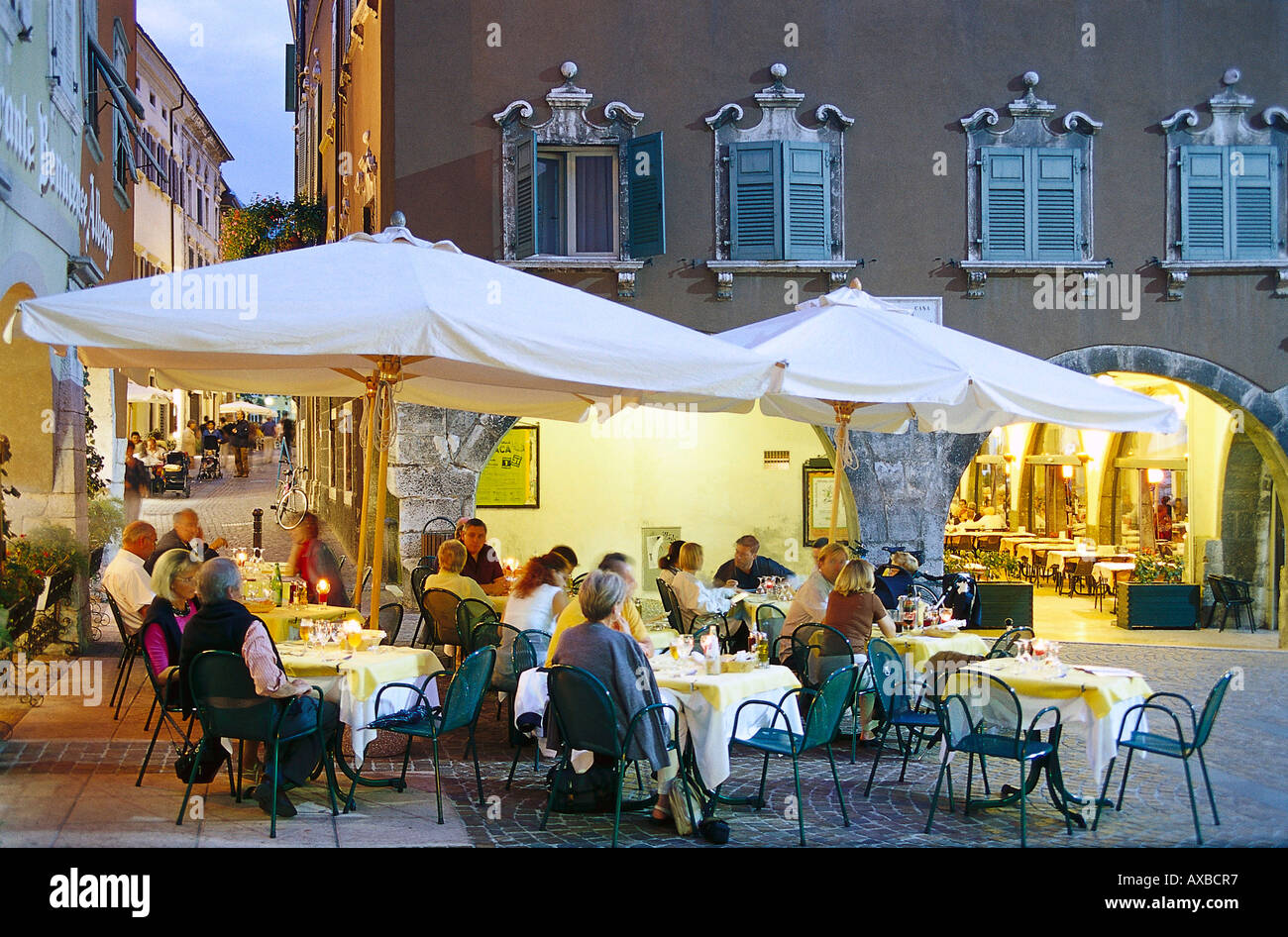 Leute sitzen an Tischen eines Restaurants am Abend, Piazza Tre Novembre, Riva del Garda, Lago di Garda, Trentino, Italien, Eu Stockfoto