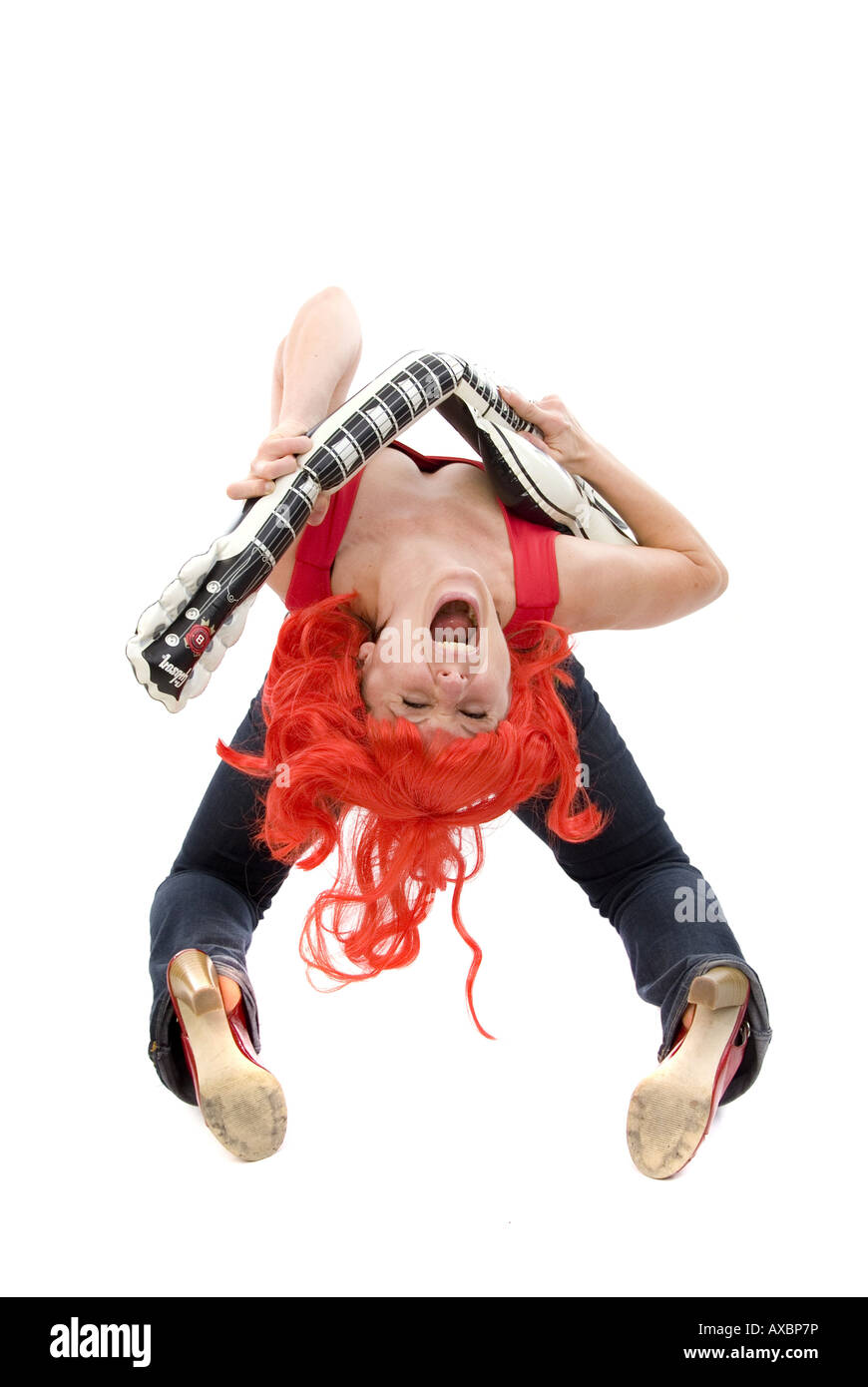 junge Frau mit einer roten Perücke, Luftgitarre zu spielen Stockfoto