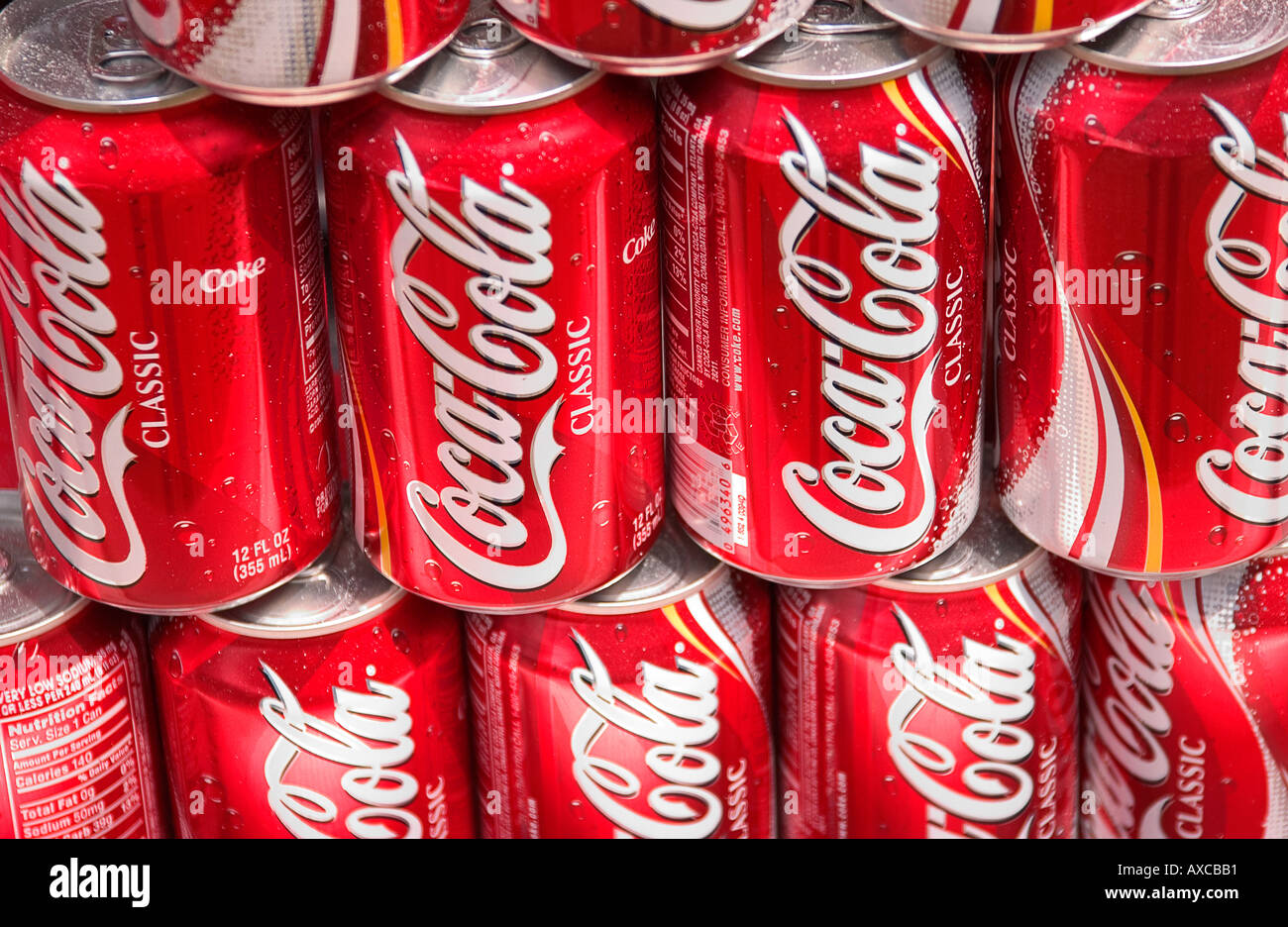 Dosen Coca-Cola™ in leuchtend rotem Branding, dicht aneinander gestapelt, USA. Stockfoto