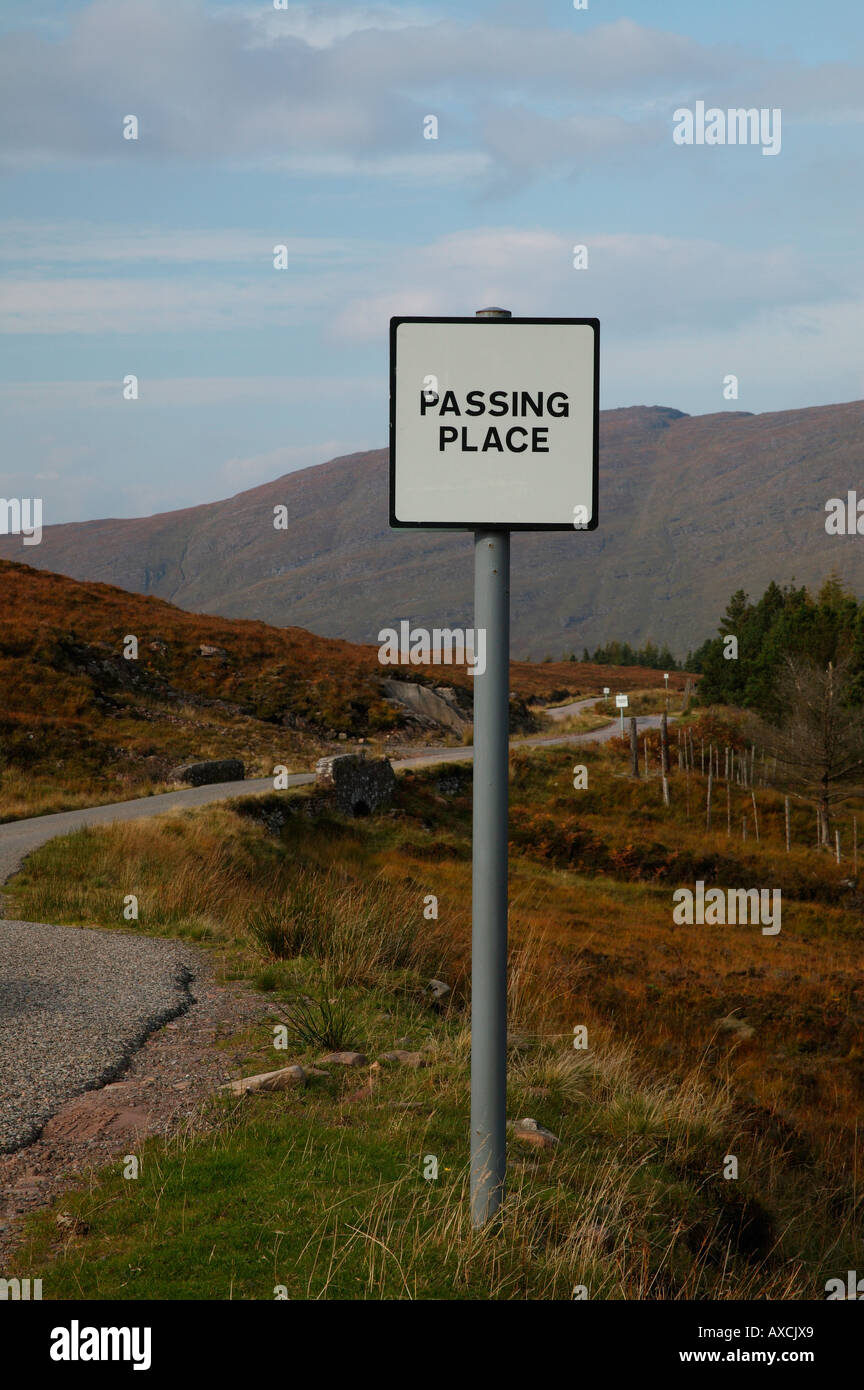 Zeichen für die Weitergabe mit Bergen und geschwungene Straße im Hintergrund Torridon, Wester Ross, Schottland, Europa statt. Stockfoto