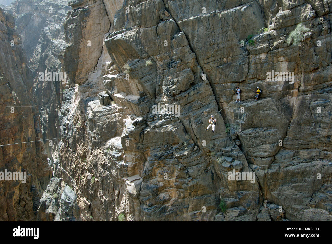 Ein Wanderer durchqueren eine Seilrutsche (alias Flying Fox) auf die Via Ferrata Wandern im Snake Canyon im Jebel Akhdar Gebirge im Oman. Stockfoto