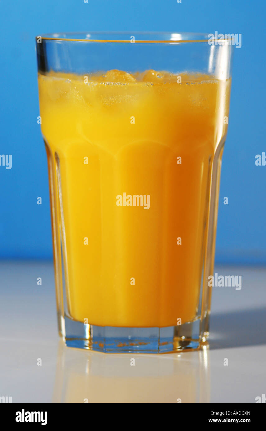 Glas frisch gepressten Orangensaft mit blauem Hintergrund Stockfoto