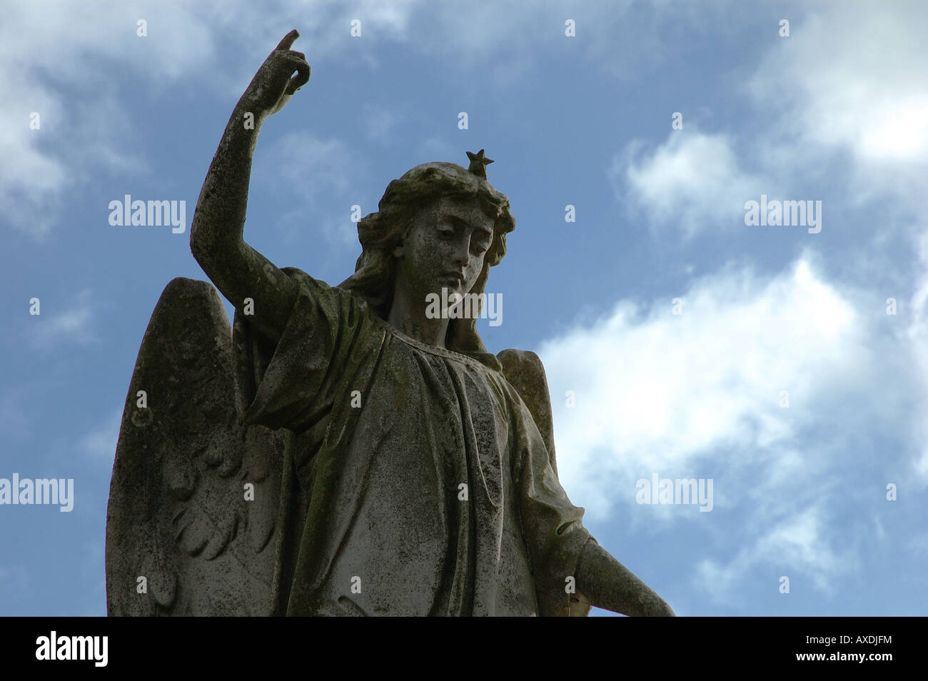 Steinfigur Engel mit Stern Krone gegen den blauen Himmel im Friedhof Stockfoto