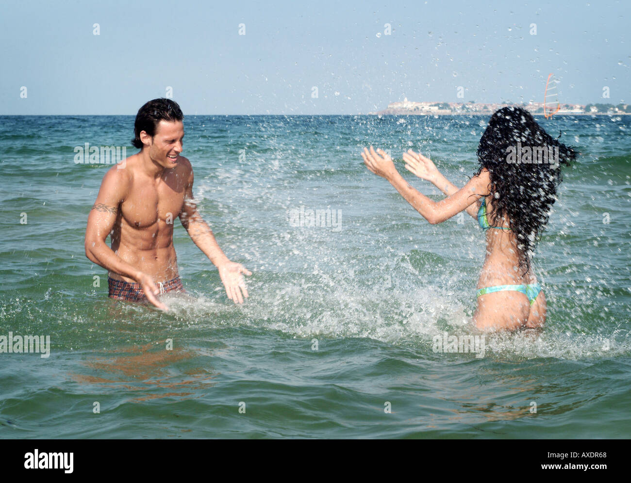 junges Paar gegenseitig mit Wasser Spritzen Stockfoto