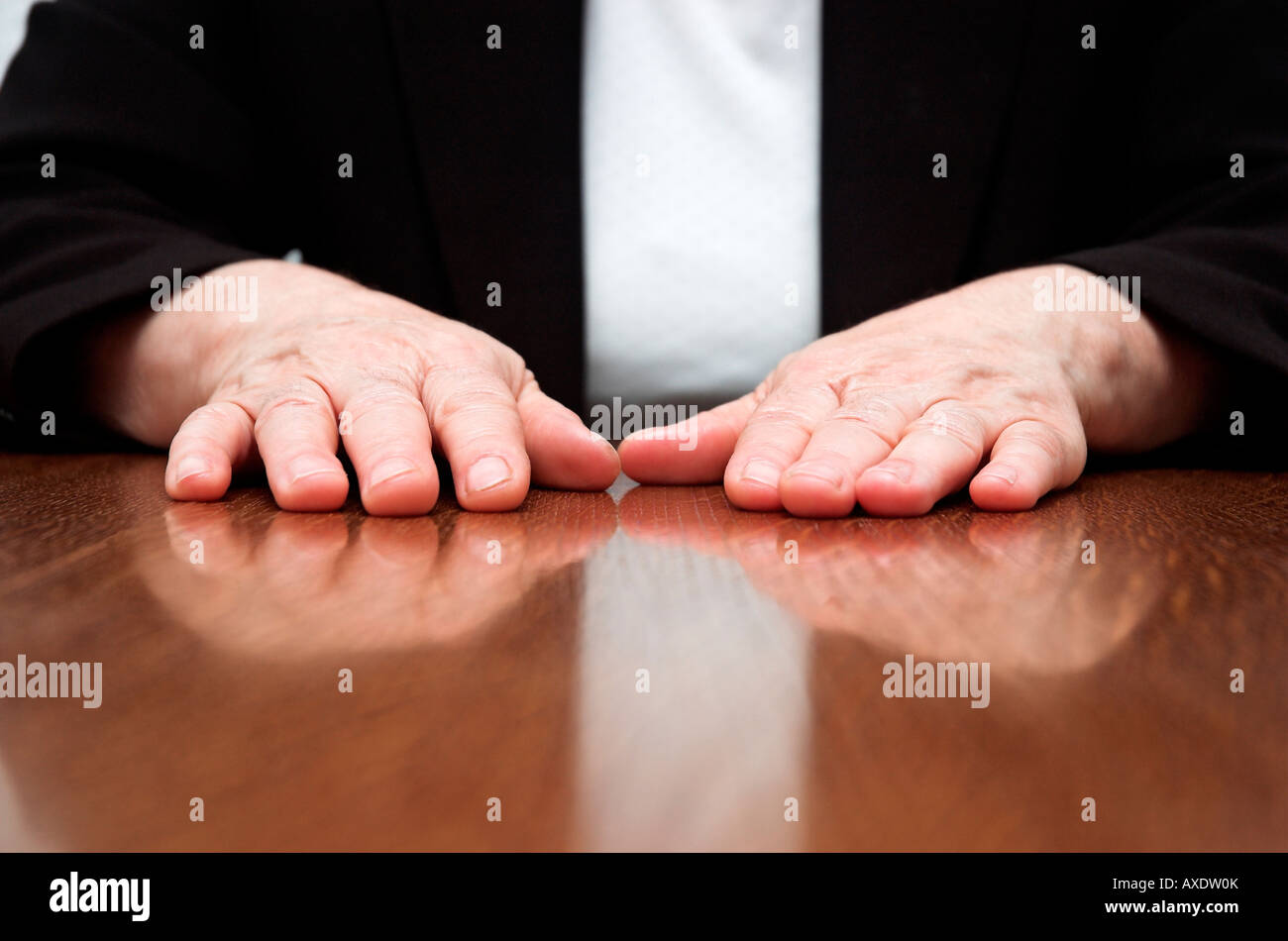 Geschäftsfrau, die sitzen am Schreibtisch im Büro mit den Händen auf den Tisch Stockfoto