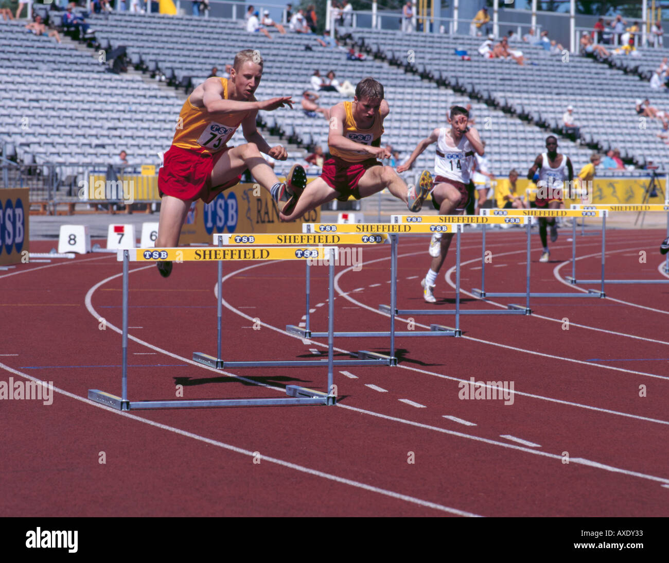 Jungen über Hürden springen, auf dem richtigen Weg mit Kunstrasen; Don Valley Stadium, Sheffield, South Yorkshire, England, Vereinigtes Königreich. Stockfoto