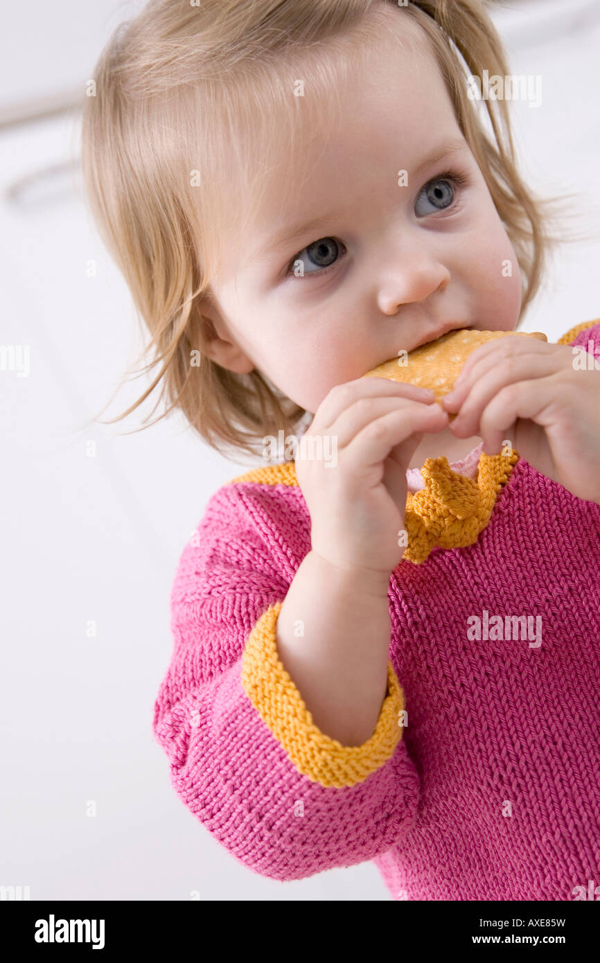 Baby Mädchen (2-3) Essen ein Biskuit, Porträt Stockfoto