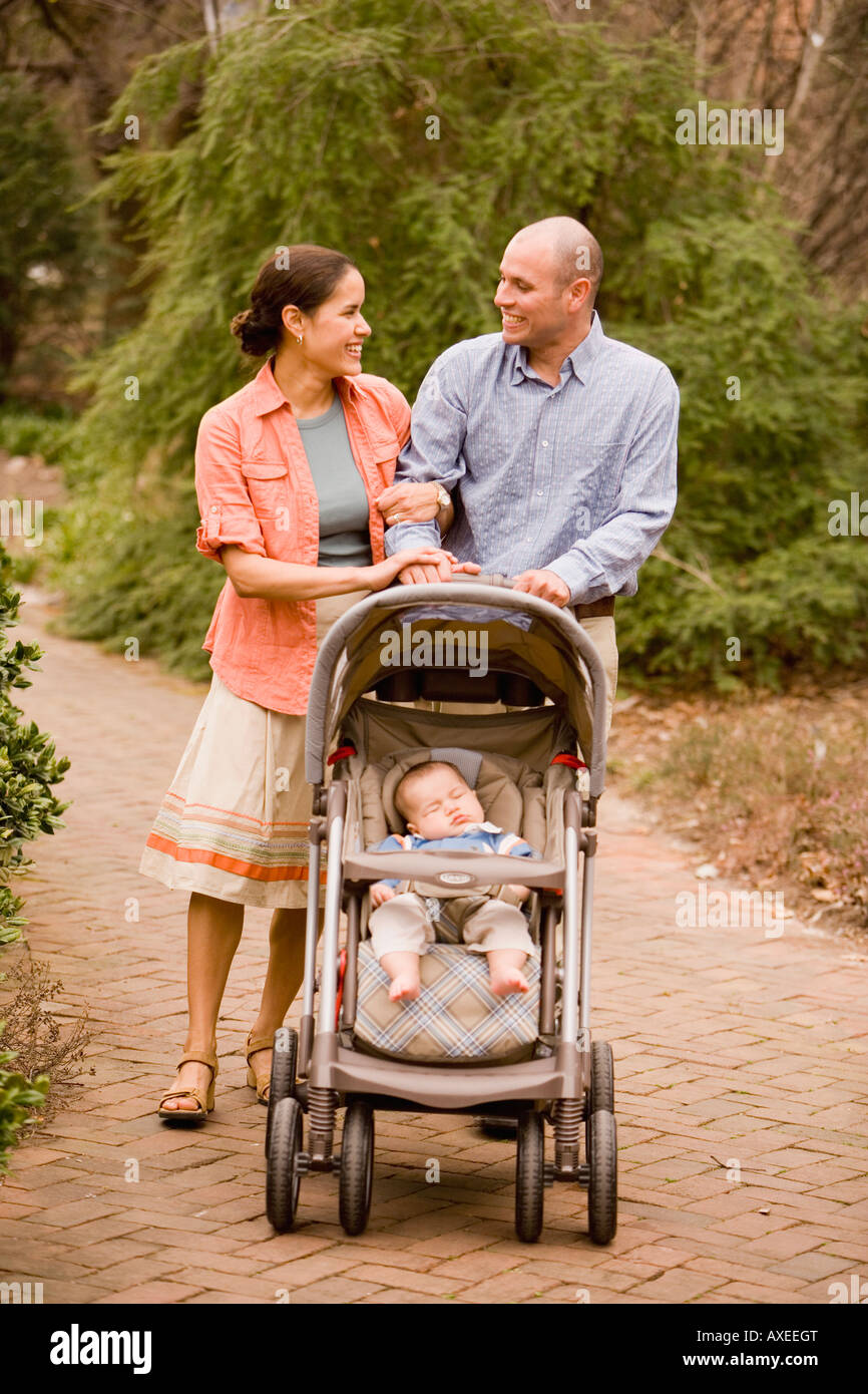 Hispanische Eltern Baby im Kinderwagen schieben Stockfoto