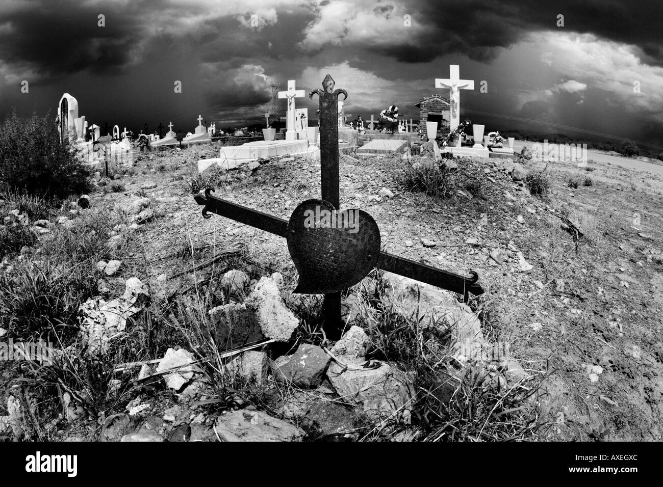 Stürmische Monsun Himmel Kreisen einen alten Friedhof von Sonora. Kreuze und ein Herz-Milagro füllen die Landschaft. Stockfoto