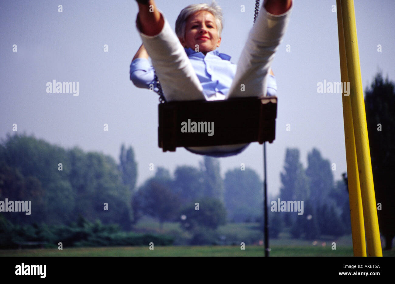 Frau weiblich Alter 55 60 60 65 alten Erwachsenen grauen Haaren weiß behaart schlank Fit Schaukel Inhalte im freien freien Tag Baum Bäume Park g Stockfoto