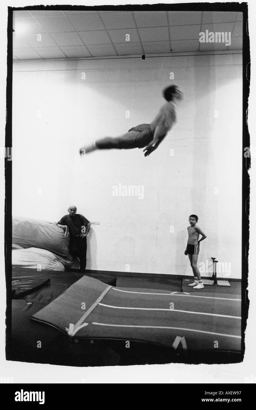 Männlich Alter 15 20 junge schlanke Passform Athlet Acrobat Trainer Erwachsene Übung Zug springen indoor Innenraum Gymnasium Sport Hall ath Stockfoto