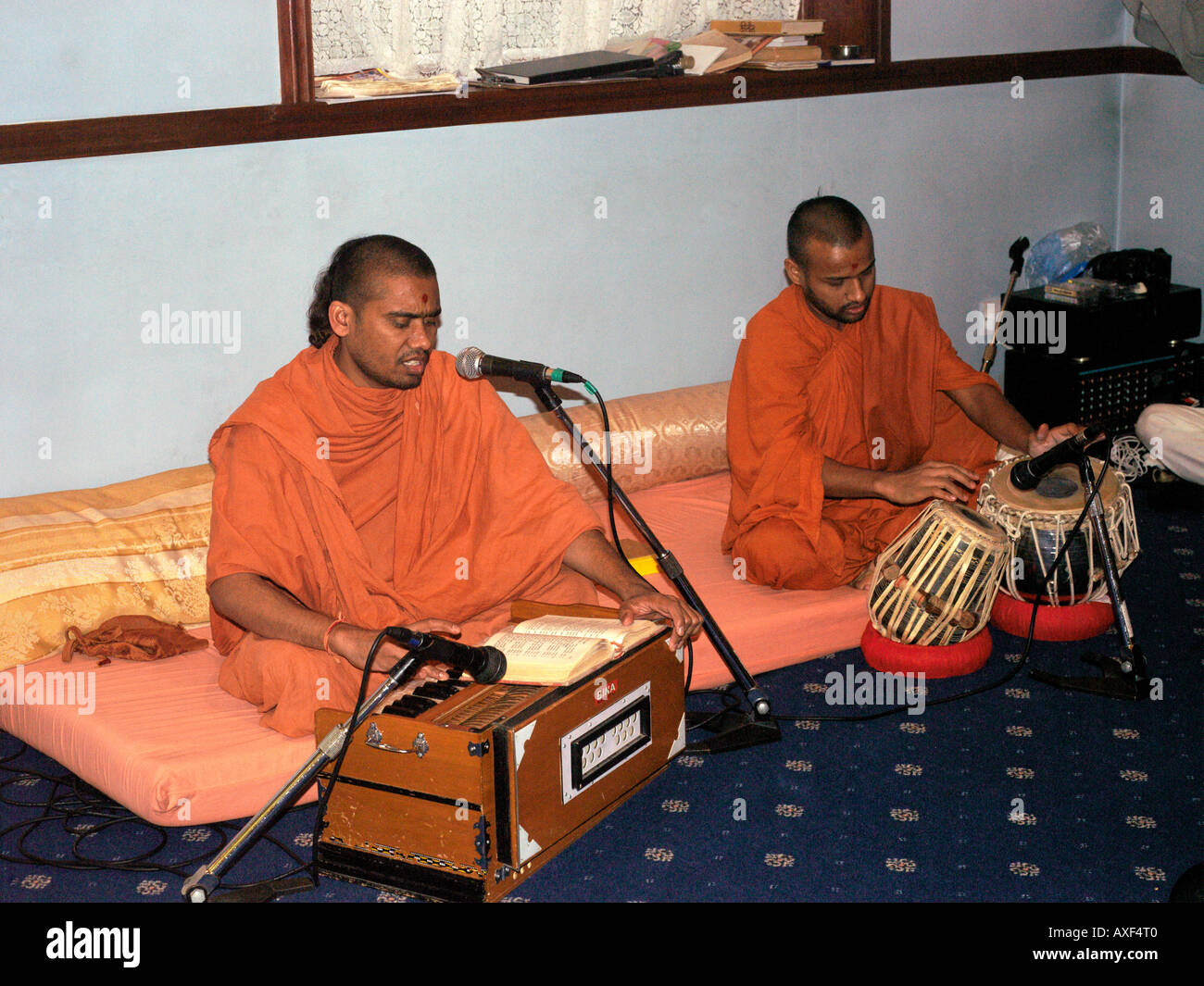 Shree Swaminarayan Tempel Streatham London England Musiker spielen in orangefarbene Gewänder Harmonium und Tabla-Trommeln an Diwali Stockfoto