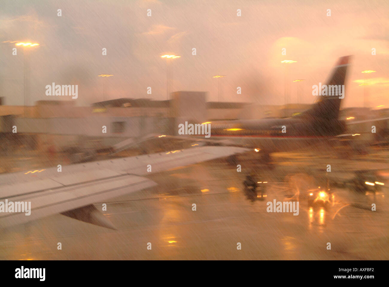 Passagierjets vor ihren Toren und auf dem nassen Asphalt in einem Regenschauer Stockfoto