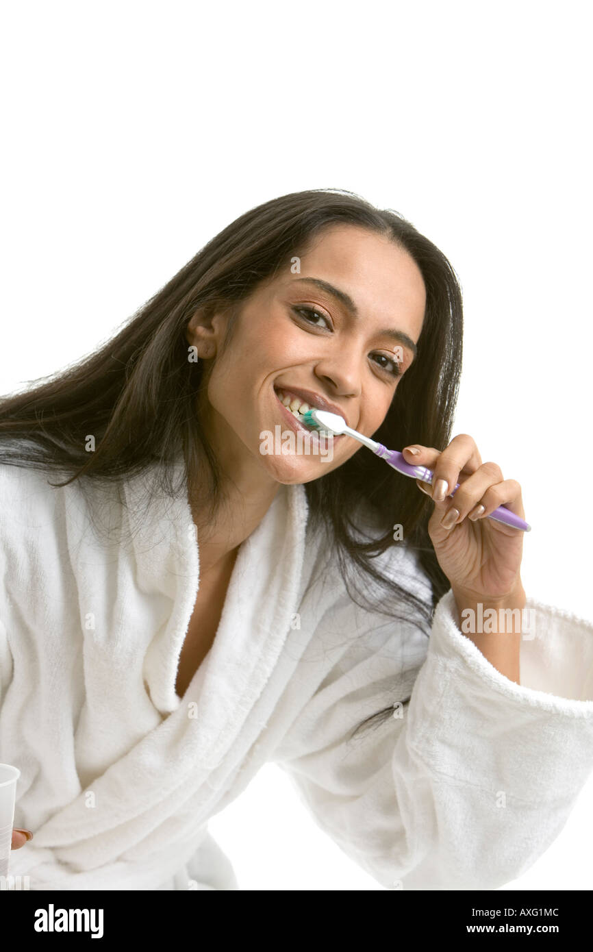 Hübsche junge Frau mit langen schwarzen Haaren, ihre Zähne zu putzen Stockfoto