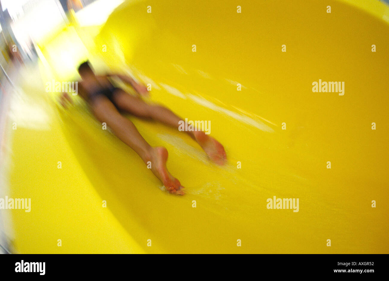 Mann in Wasserrutsche am Pool hinunter zu rutschen. Stockfoto