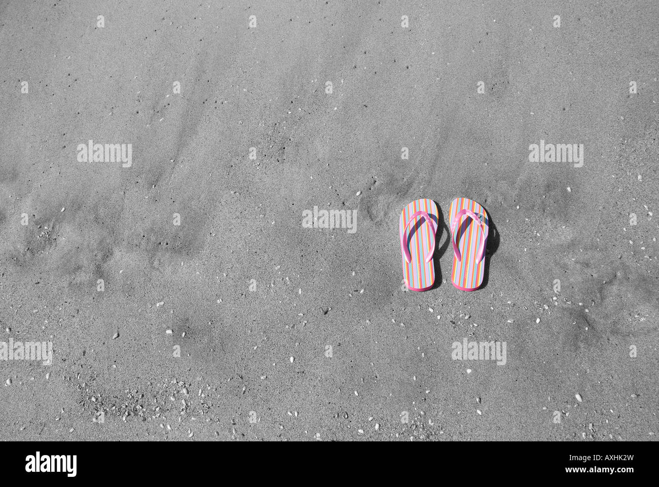 Ein paar rosa Flip flops im sand Stockfoto