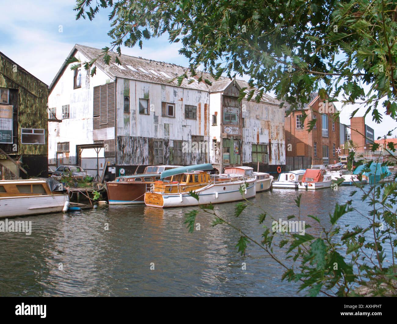 Fluss Wensum mit Booten und alte Wellpappe Lagerhäusern am Riverside Norwich Norfolk England UK Stockfoto