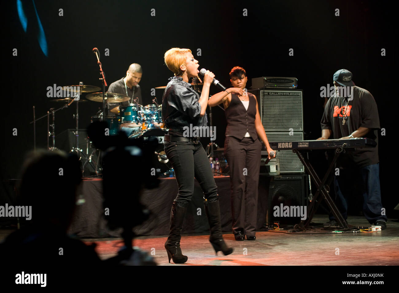 ILLINOIS-Chicago-Leistung von Keyshia Cole im Vic Theater hält Mikrofon Schlagzeuger Keyboarder und Sänger Stockfoto
