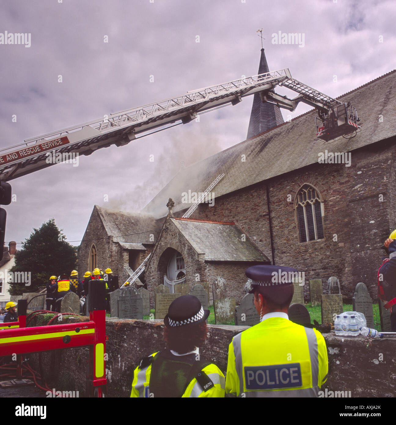 Feuerwehrleute, die Dachziegel zu entfernen, wie sie eine Kirche Brandgefahr durch Kleinkinder an der St. Brannocks Kirche Braunton Devon England angehen Stockfoto