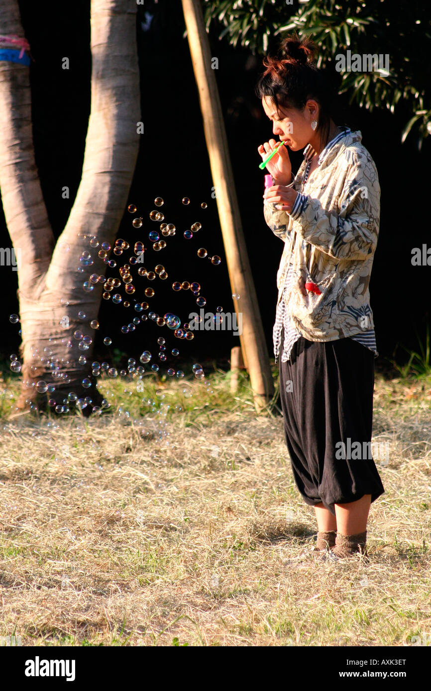 Japanische Frau bläst Seifenblasen in Yoyogi-Park (Yoyogi-Koen), Tokio, Japan Stockfoto