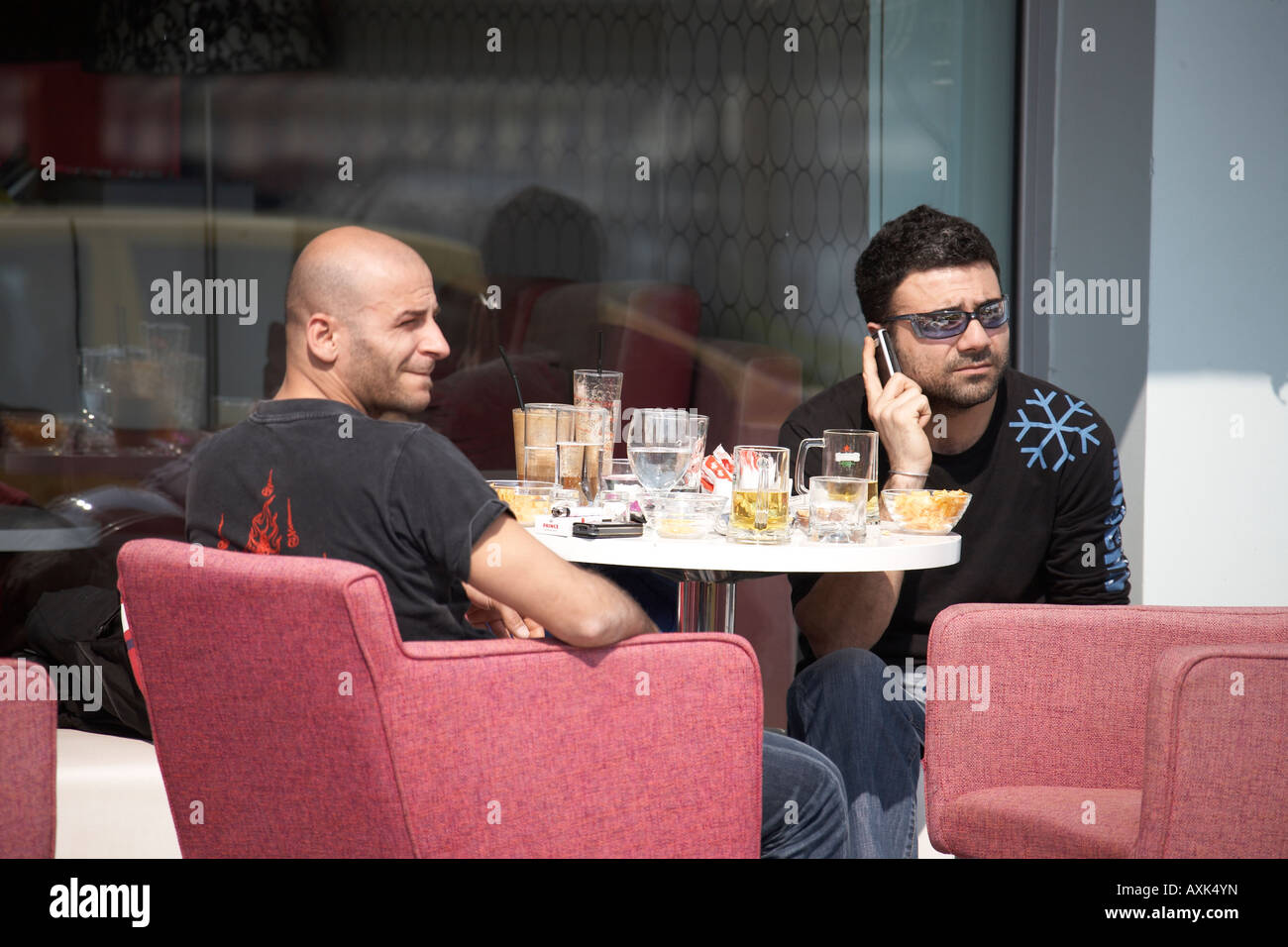 Cafe mit zwei Männer trinken in Mikrolimano oder verschiedene alten kleinen Hafen Hafen in Piräus oder Pireas Athen Griechenland Stockfoto