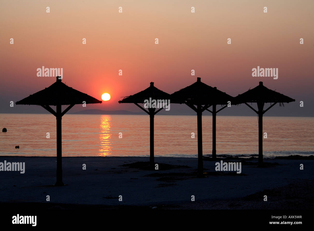 Rot-Orange und Gold Farben auf den Sonnenuntergang ins Meer mit Schattierungen in der Silhouette bei Sonnenuntergang mit Spiegelungen im Wasser Stockfoto