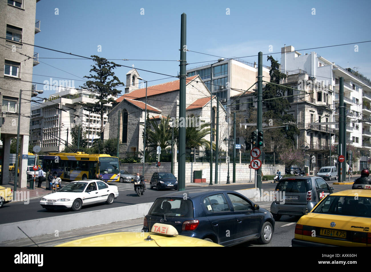Kirche und Gebäude verdeckt durch Straßenbahn Kabel mit Verkehr auf Andrea Singrou Straße in Athen oder Athini Griechenland Stockfoto