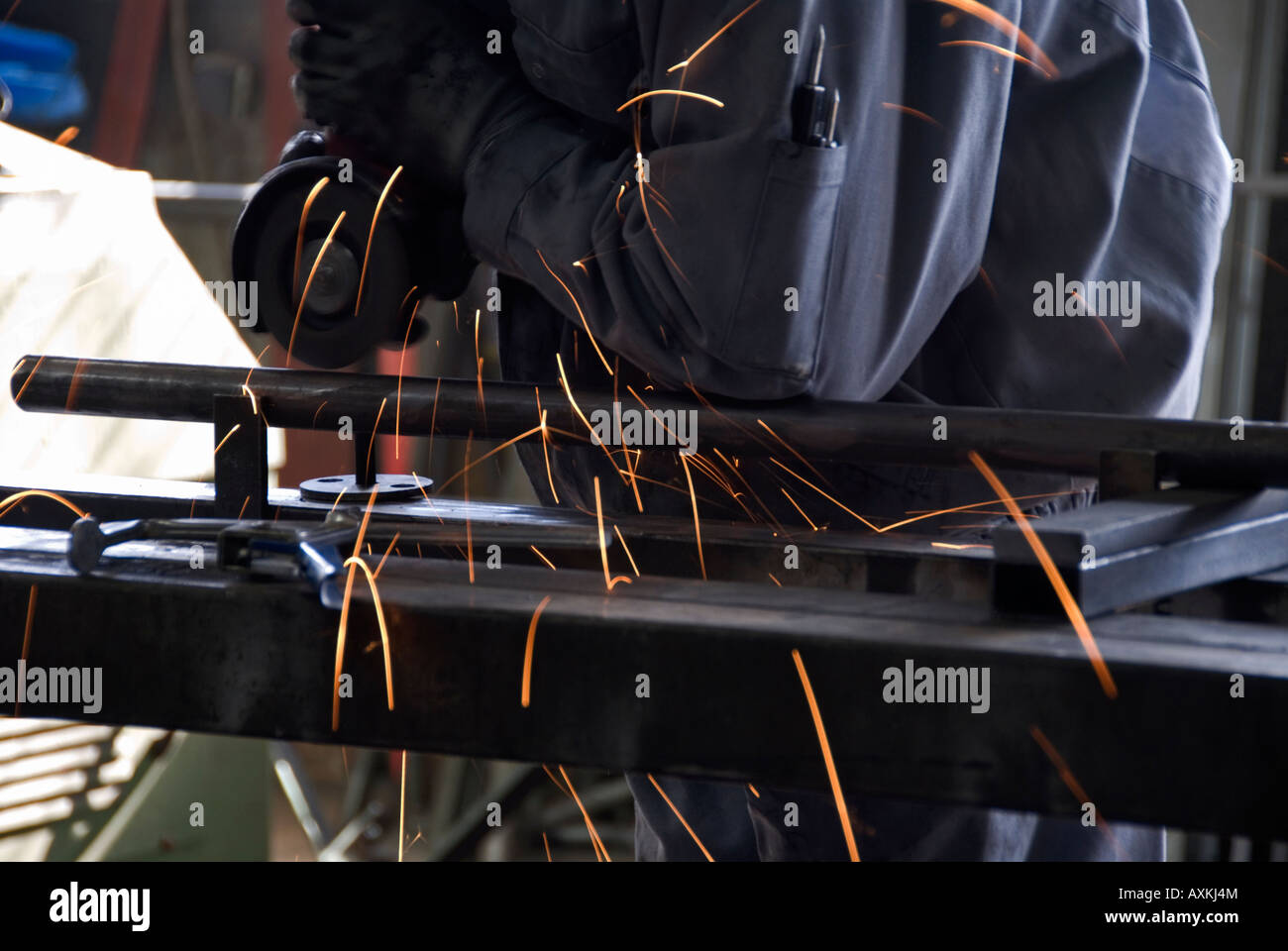 Stock Foto von Fabrikarbeiterin Schleifen Metall flach mit einer elektrischen Schleifer Stockfoto