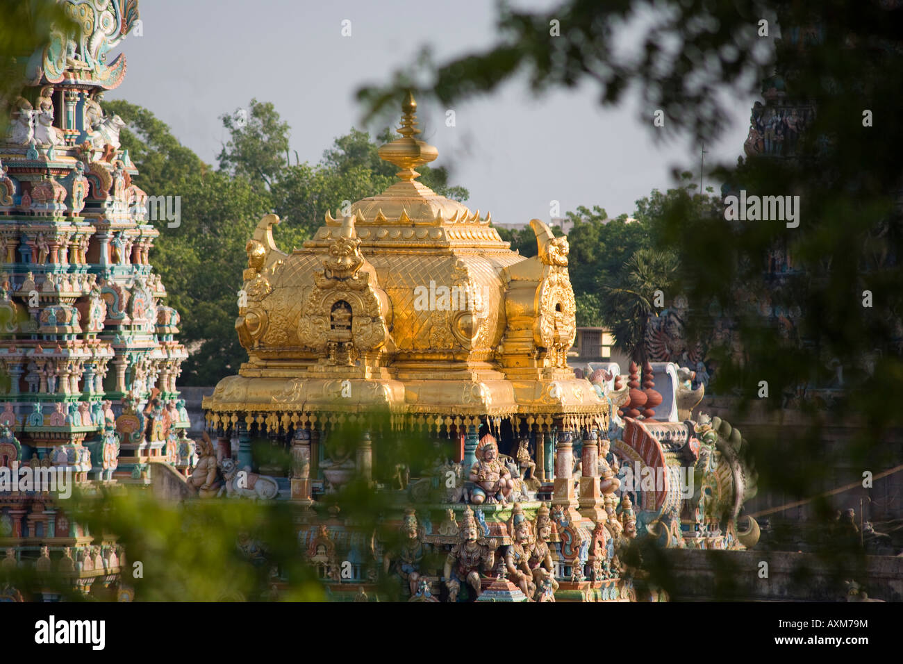 Blick durch Bäume, goldene Turm der Meenakshi Tempel, Madurai, Tamil Nadu, Indien Stockfoto