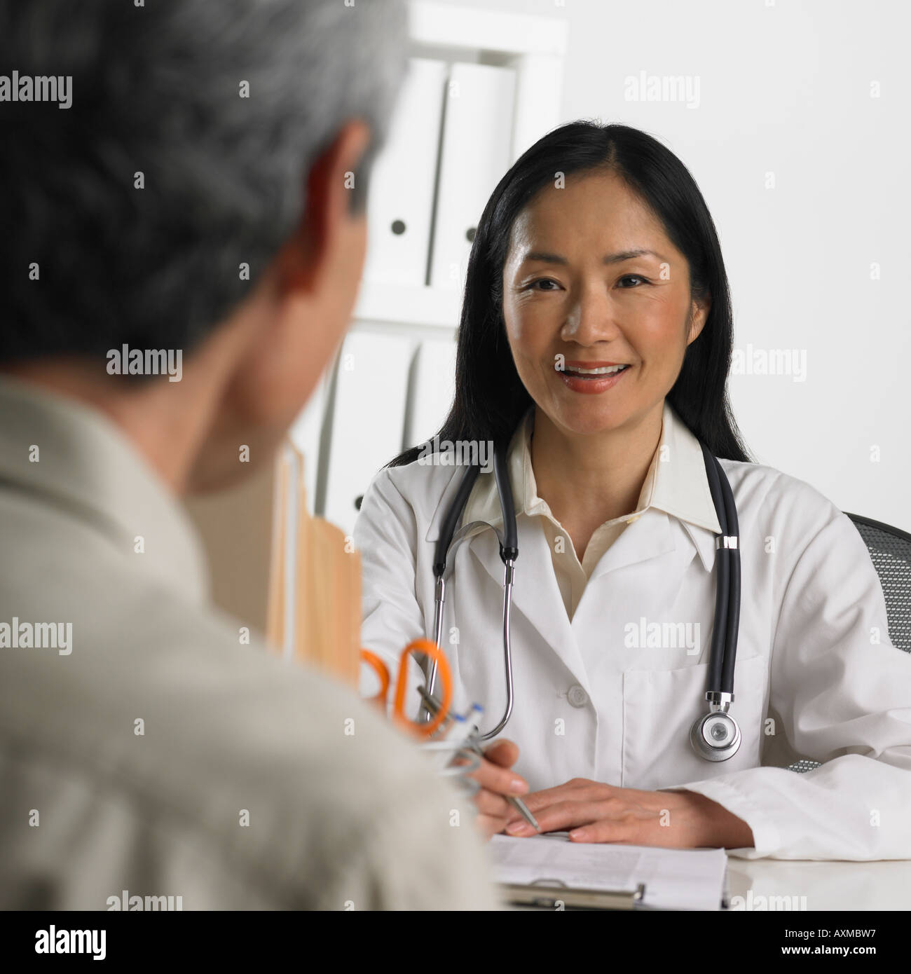 Asiatische Frauen Arzt im Gespräch mit Patienten Stockfoto