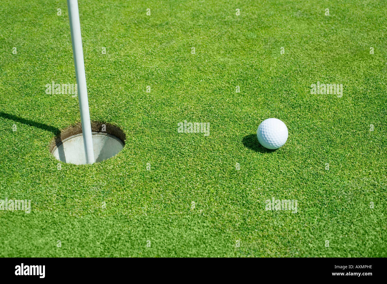 Golfball in der Nähe von Cup am Putting Green im freien Stockfoto