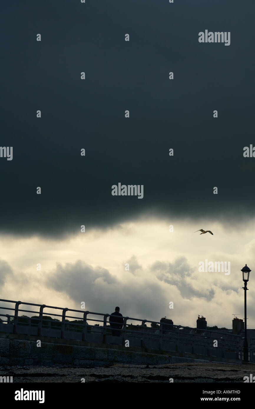 Mann zu Fuß dunkle Wolken Stockfoto