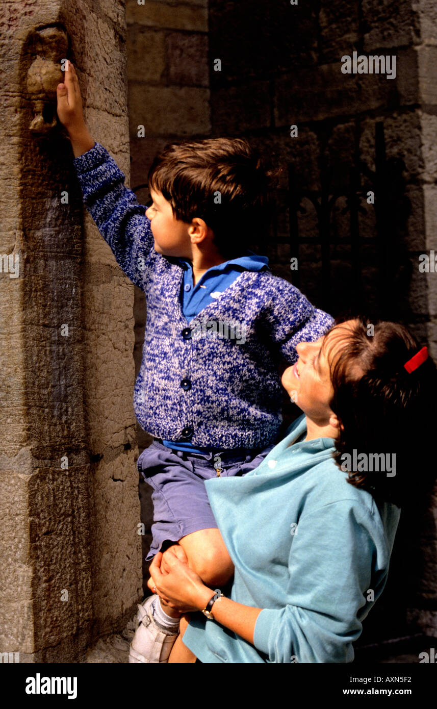 kleiner Junge wird von seiner Mutter zu berühren aufgehalten, ist die berühmte Eule ist das Symbol für die französische Stadt Dijon Stockfoto