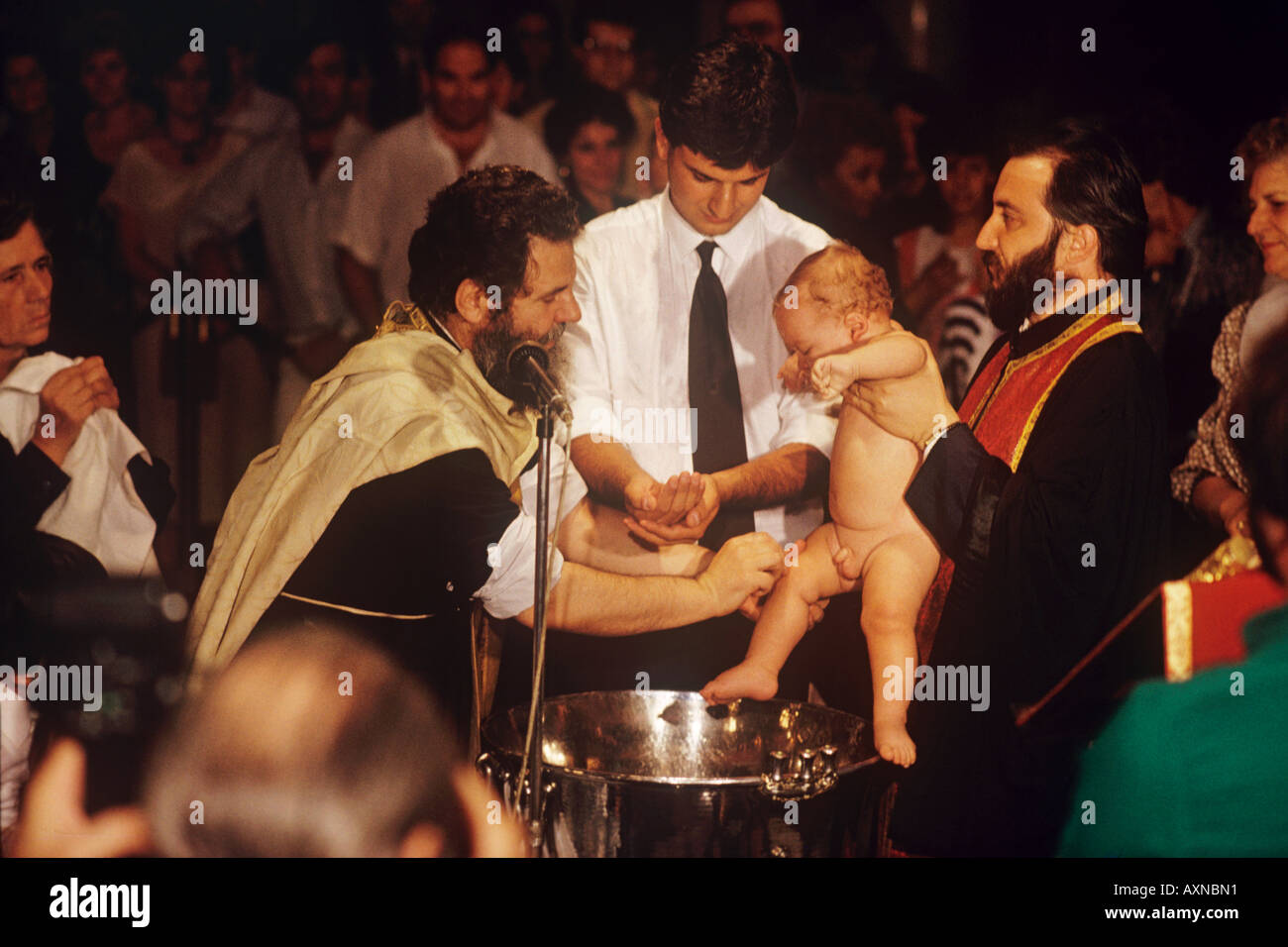 Inder griechisch-orthodoxen KircheDie Sacrementof Baptismthe Kind ist gesalbt überall mit Olivenöl Andcompletely in Wasser getaucht Stockfoto