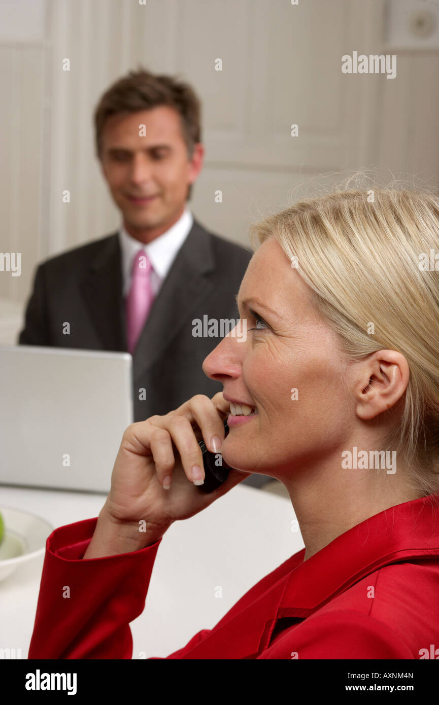 Junge, blonde Frau ist vor einem Mann, der mit einem Laptop, selektiven Fokus arbeitet telefonieren Stockfoto