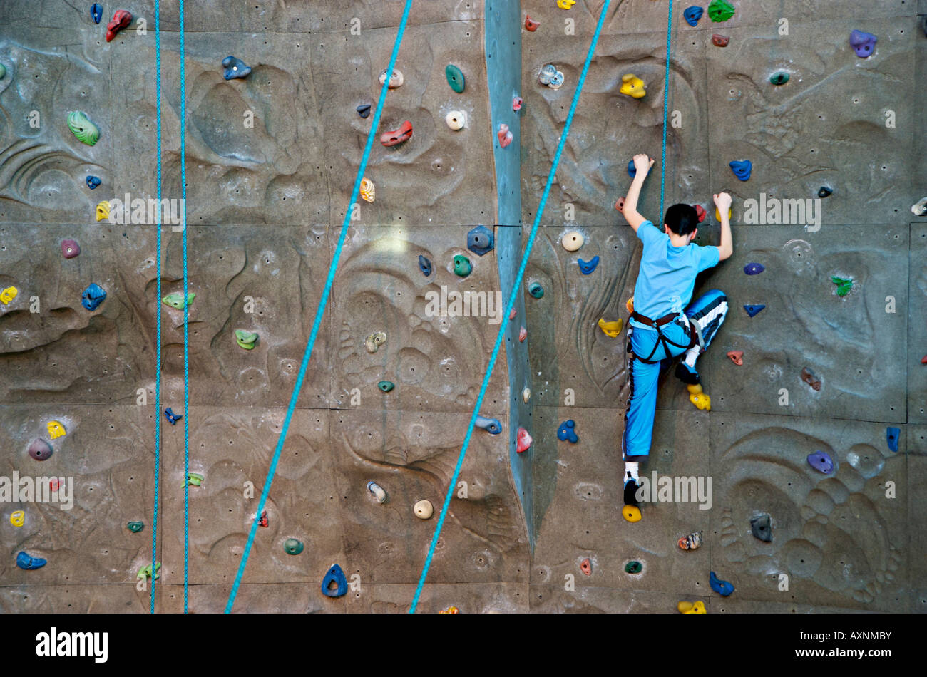 Junge Skalierung eine indoor Kletterwand. Stockfoto