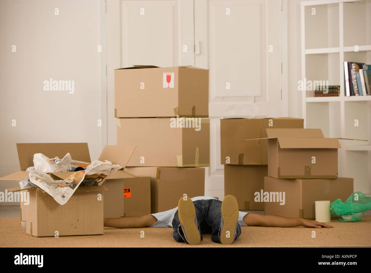 Mann auf Boden neben Umzugskartons Stockfoto