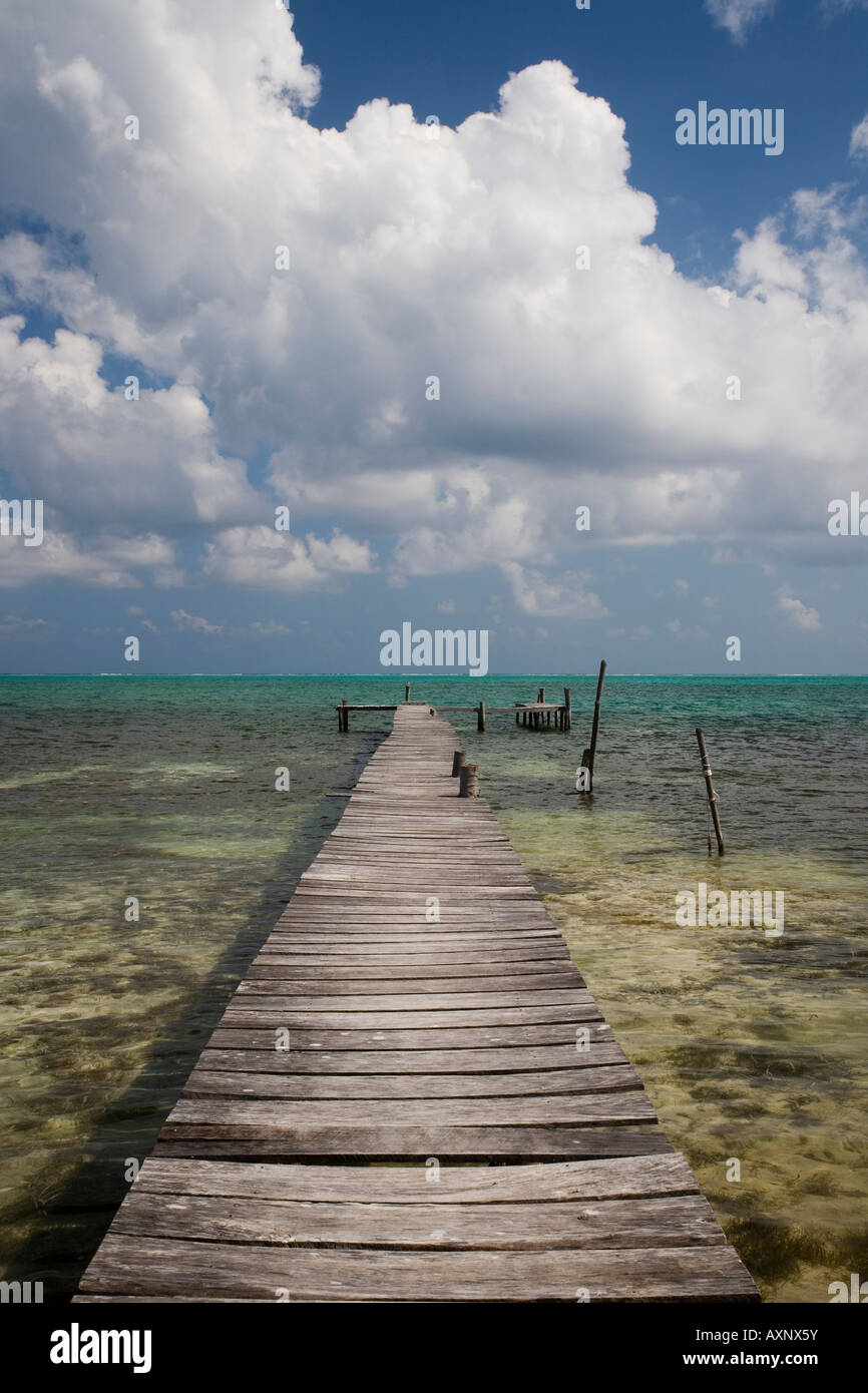 BELIZE CAYE CAULKER INSEL, PIER WIE KORRIDOR FÜHRT ZU A KLAR KARIBIK MIT BEEINDRUCKENDEN WEIßEN WOLKEN-BILDUNG Stockfoto