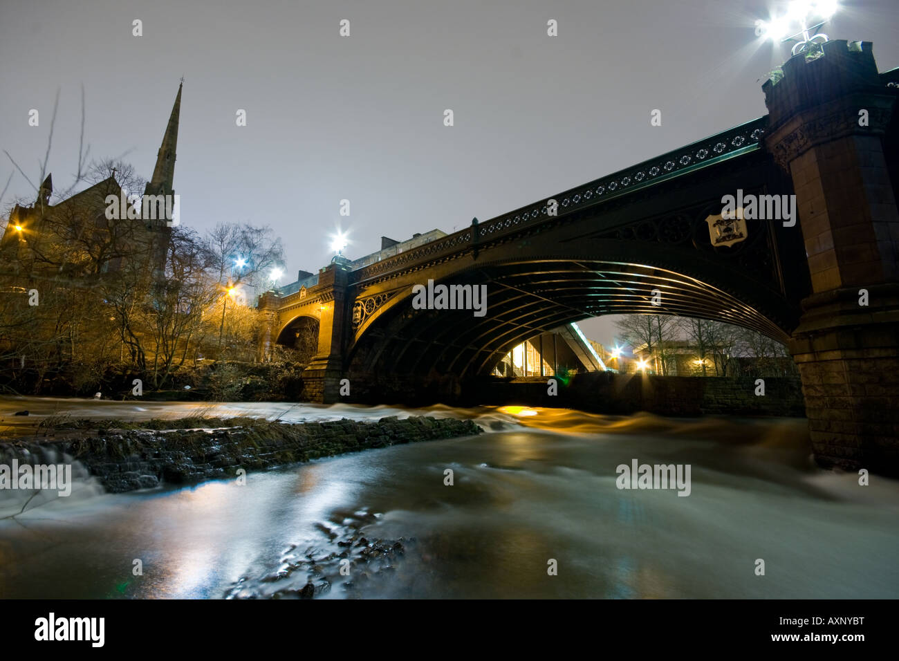 Eine Brücke über einen Fluss in der Nacht, mit Reflexionen. Stockfoto