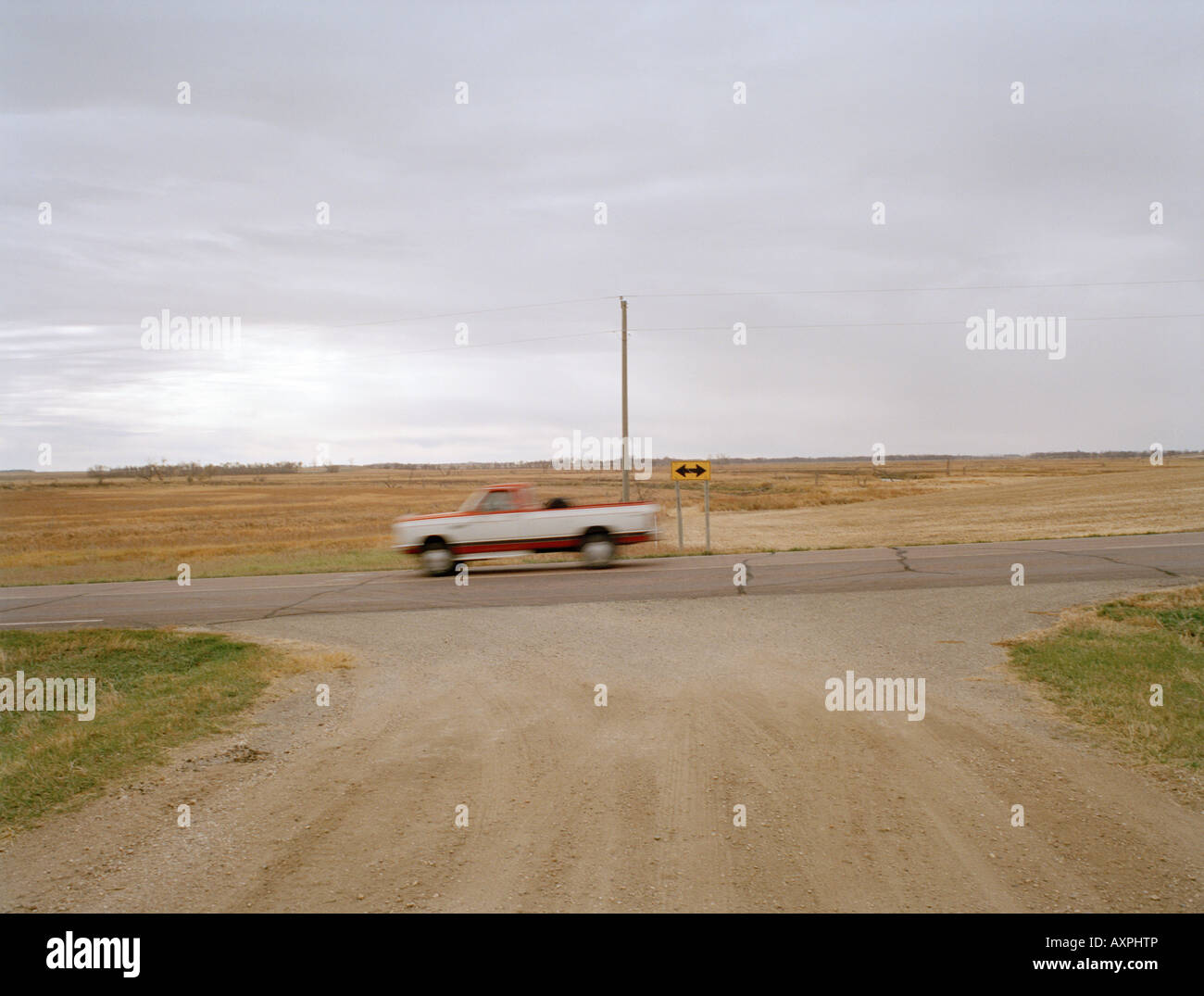 Ein Pickup-Truck beschleunigt Vergangenheit ein einfaches zwei-Wege-Schild in der Mitte von nirgendwo in Amerika. Stockfoto