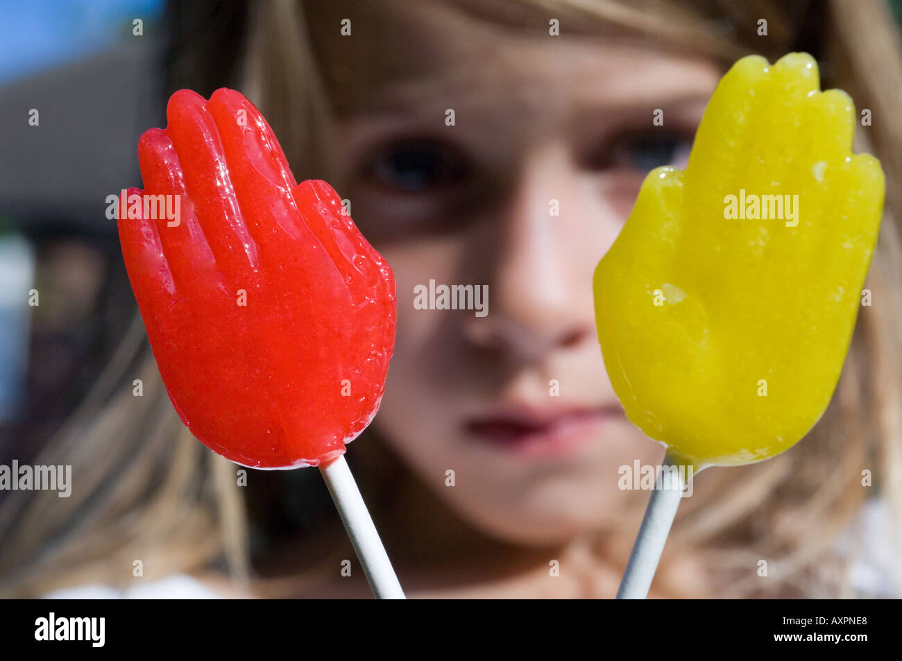 rote und gelbe Lutscher vor schweren Kind Stockfoto
