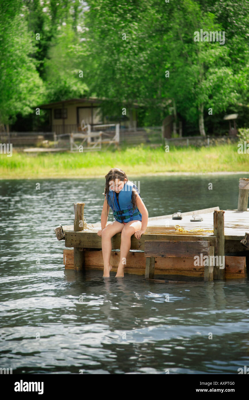 Junge Mädchen sitzen auf dock Stockfoto