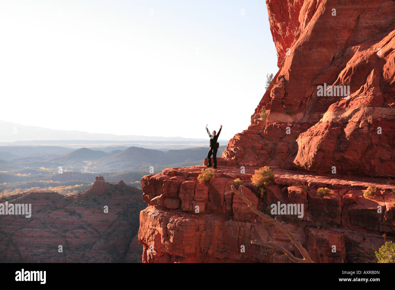 WEIBLICHE WANDERER AUF EINEM FELSVORSPRUNG AUF KATHEDRALE FELSEN IN SEDONA ARIZONA USA Stockfoto
