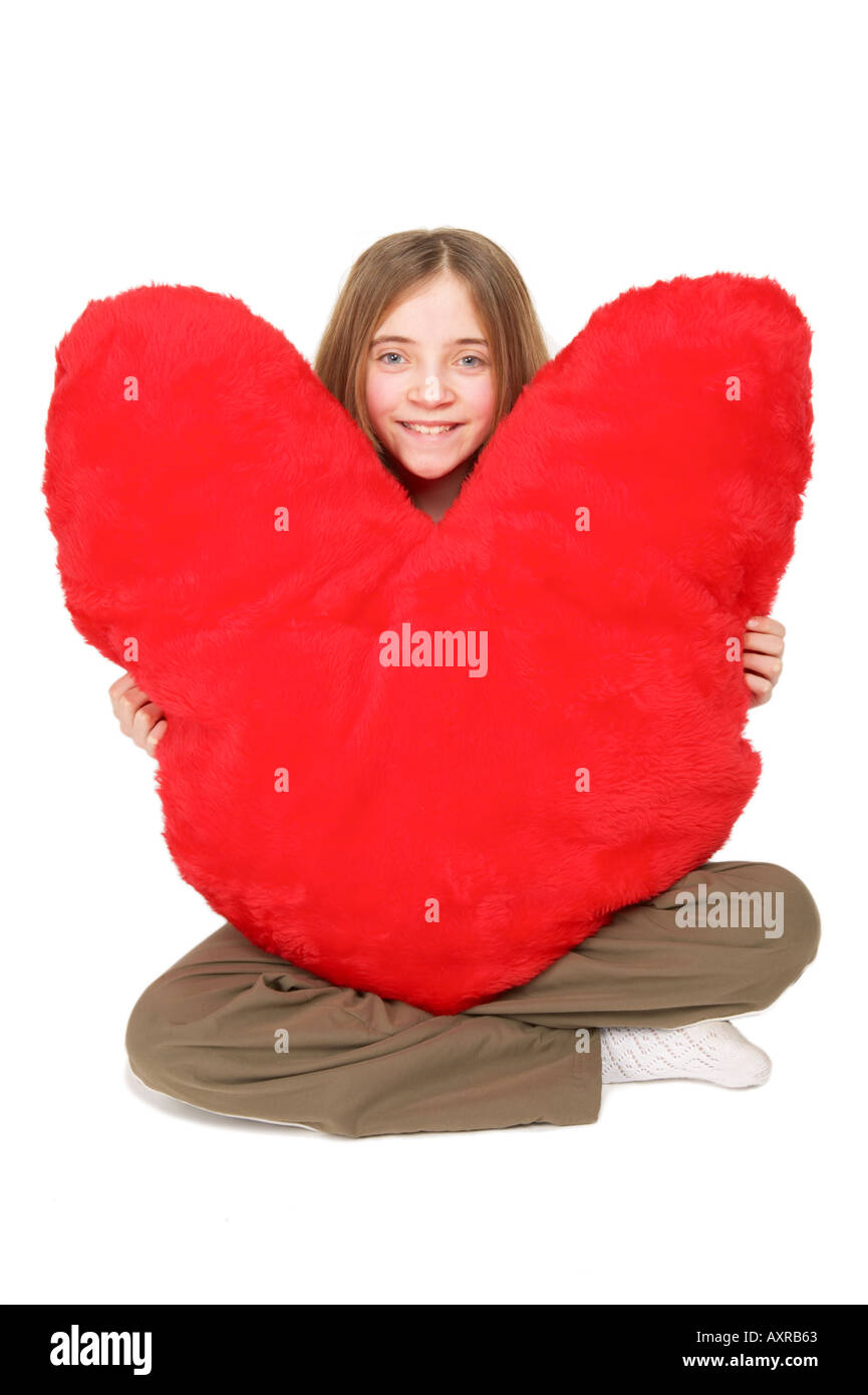 Neun Jahre altes Mädchen mit riesigen roten Herzen Stockfoto