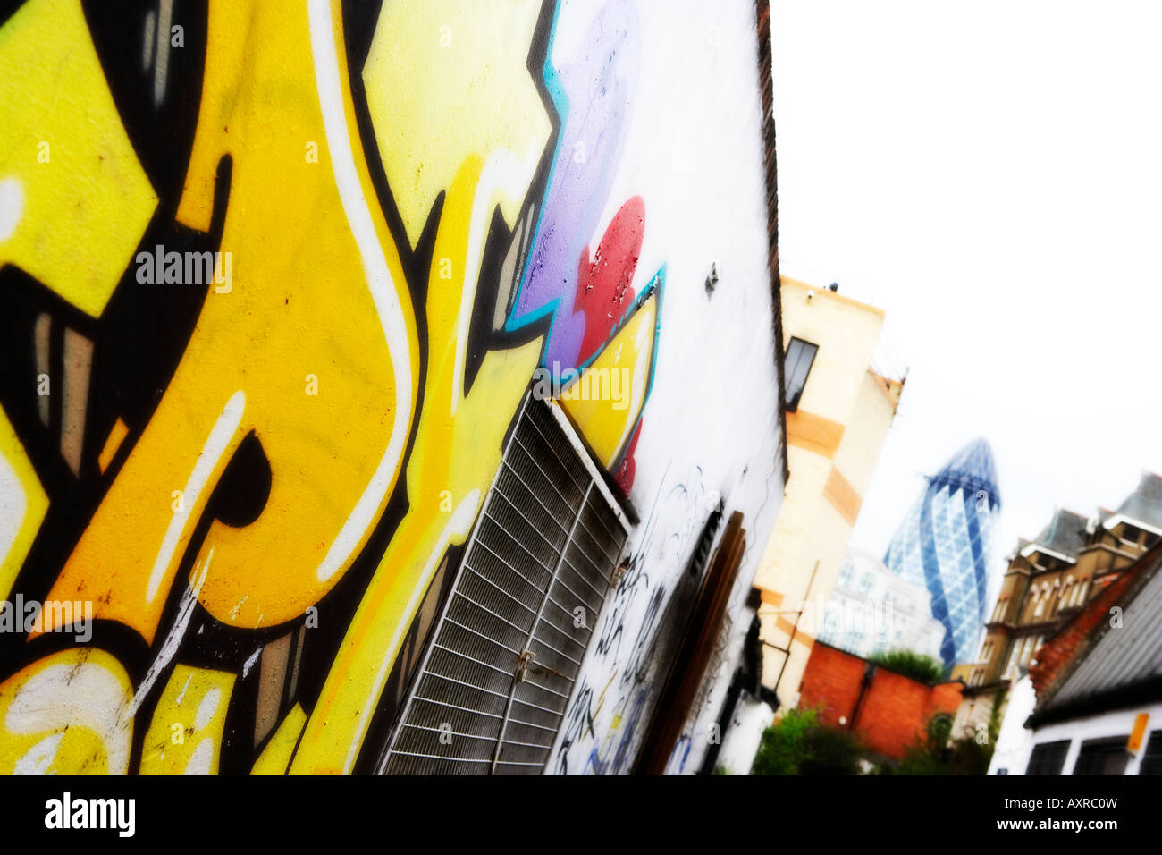 Graffiti an der Wand mit London Gherkin Swiss Re Gebäude im Hintergrund. Stockfoto