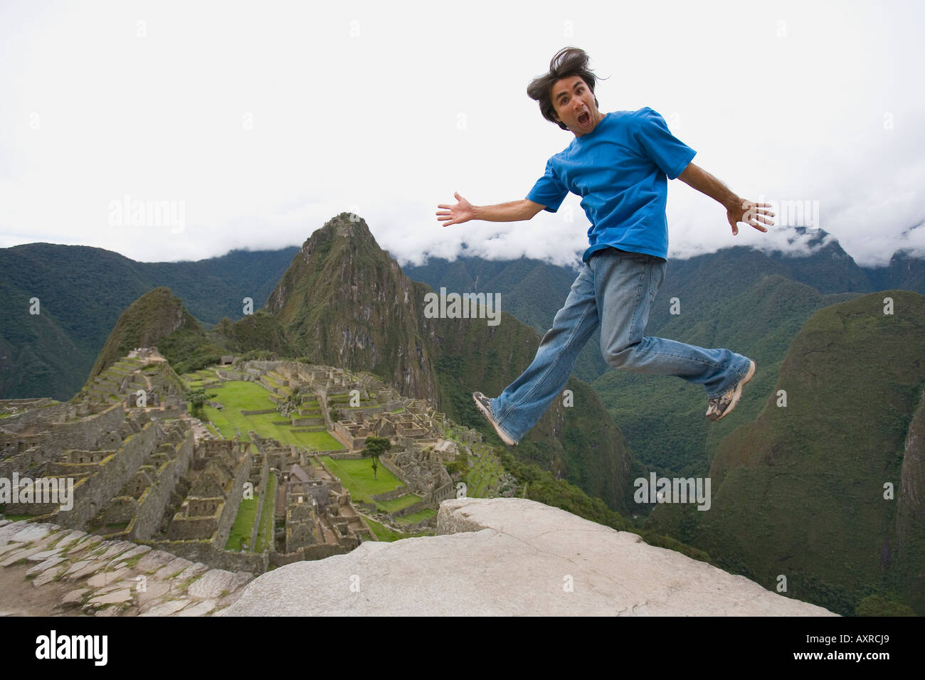 Machu Picchu Peru; Mann springt in der Nähe einer präkolumbianischen Inka-Stätte erbaut um 1460 n. Chr. Stockfoto