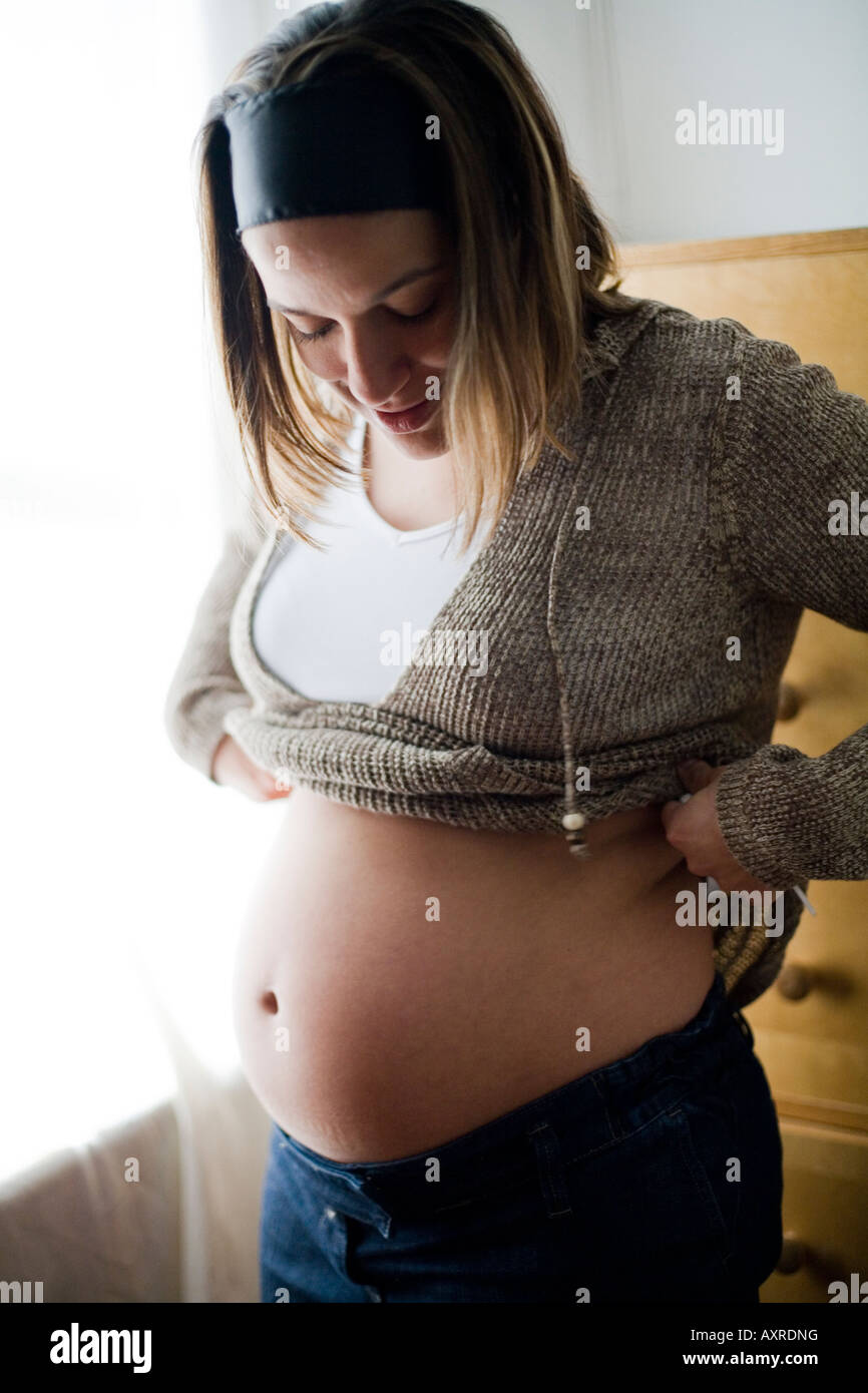 Schwangere Frau blickte auf ihren Bauch. Stockfoto