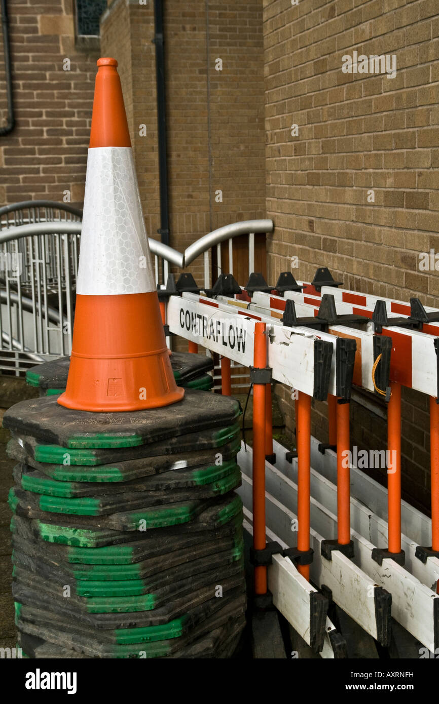 Nahaufnahme von PVC fluoreszierende Contra Fluss Straße Zapfen und Barrieren gestapelt gegen eine Gebäudewand in UK Stockfoto