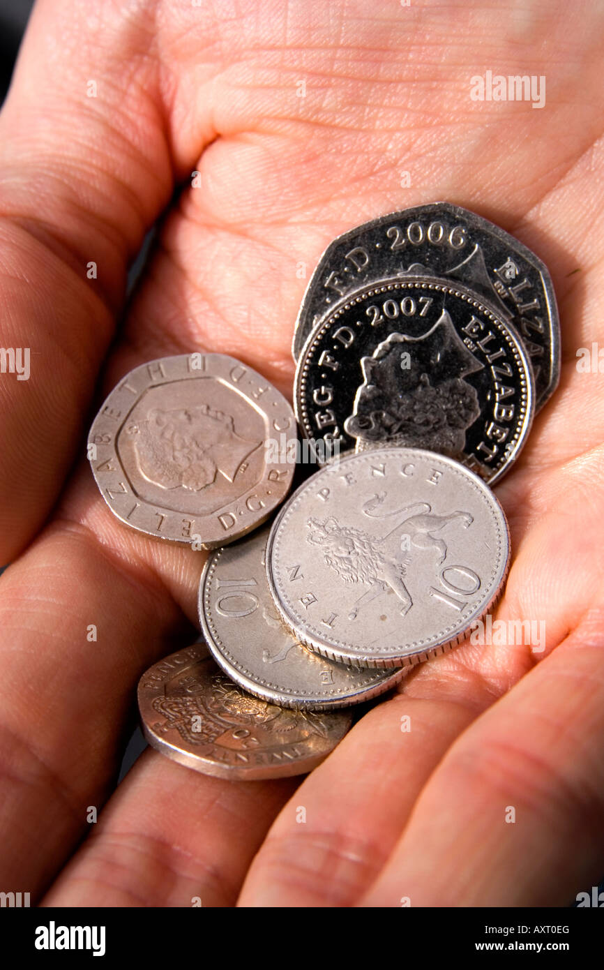 Britische Münzen in der Handfläche der Hand eines Mannes Stockfoto